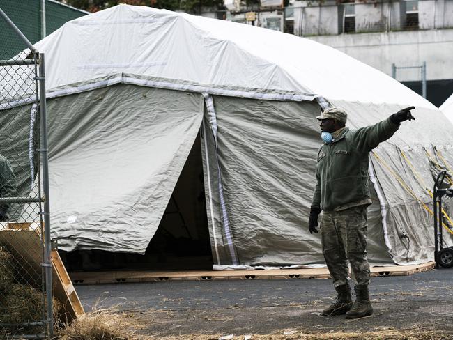 An Air Force member gives instructions as workers and members of the National Guard build a makeshift morgue outside of Bellevue Hospital in New York City. Picture: AFP