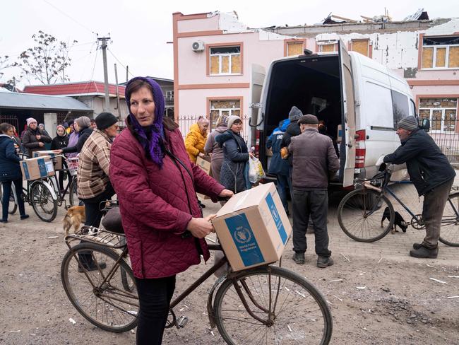 A local resident rides her bike after receiving humanitarian aid in the liberated village of Pravdyne, Kherson region. Picture: AFP