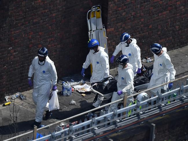 Police forensics carry a stretcher with a body bag out of the Grenfell Tower block. Picture: Getty