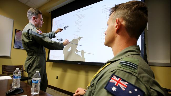 Squadron leader Wing Commander Darren Clare briefs Flight Lieutenant “Damo” before a flight . Picture: Nathan Edwards