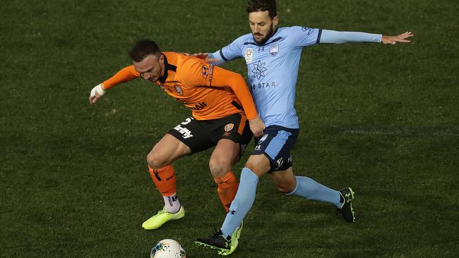 Milos Ninkovic of Sydney FC and Tom Aldred of the Roar compete for the ball.