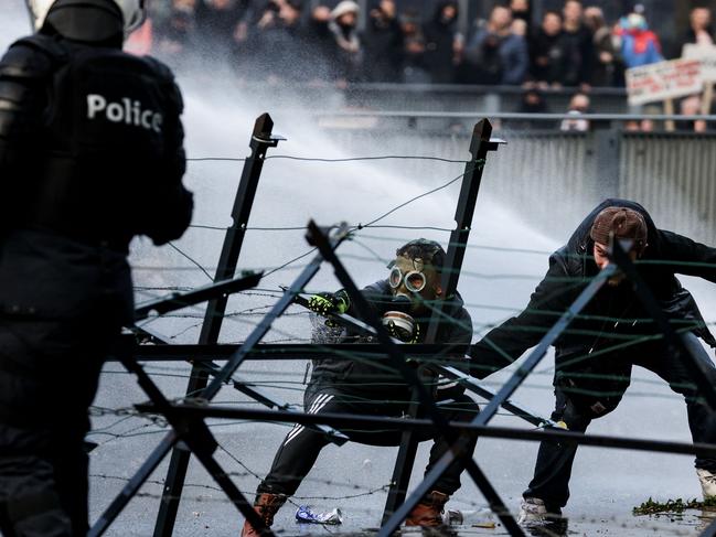 Police use a water canon to disperse demonstrators as clashes erupted in Brussels. Picture: AFP