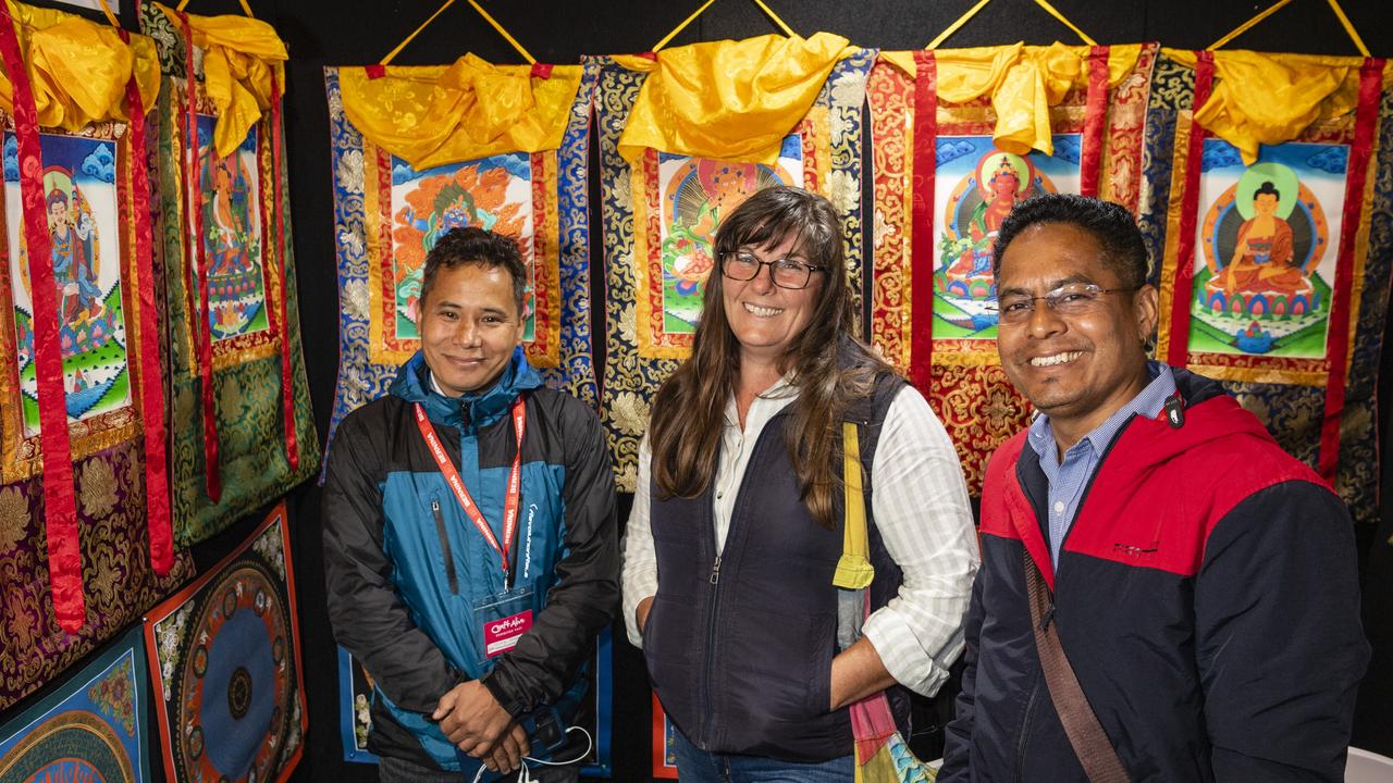 Abhaya Moktan (left) and Netra Chhatkuli of NS Handicraft Export show Debra Lynch the Nepalese thangkas on display at Craft Alive at the Goods Shed, Sunday, May 22, 2022. Picture: Kevin Farmer