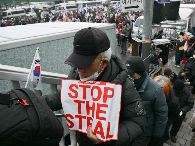 Pro- and anti-Yoon protesters braved the snowstorm. Picture: Anthony Wallace/AFP