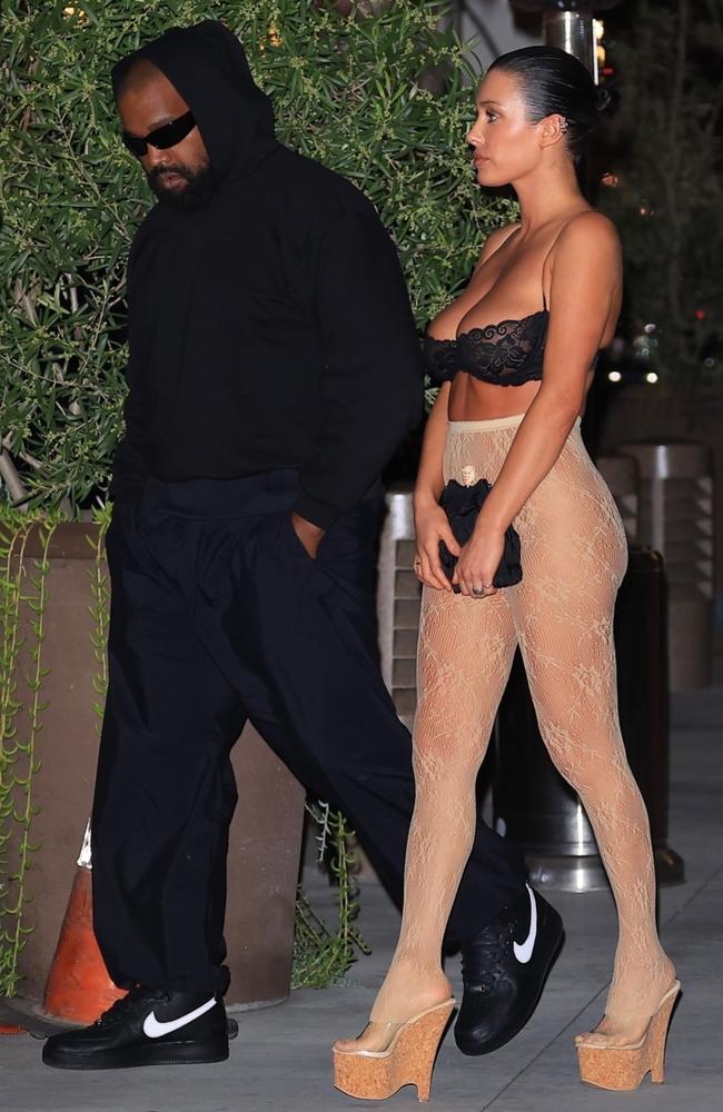 The Aussie architect and model hid her modesty behind a black, oversized clutch bag that matched her lacy bra. Side note: looks like Kanye’s traded Adidas for Nike. Picture: GAMR/KHROME / BACKGRID