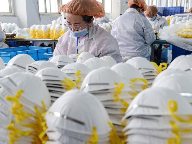 (FILES) This file photo taken on February 28, 2020 shows workers producing face masks at a factory in Handan in China's northern Hebei province. - As the COVID-19 coronavirus pandemic that originated the central Chinese city of Wuhan has gone global, thousands of factories in China have nimbly turned to a new and very profitable market -– face masks for export. (Photo by STR / AFP) / China OUT / TO GO WITH Health-virus-China-economy-masks,FOCUS by Qian Ye and Helen Roxburgh