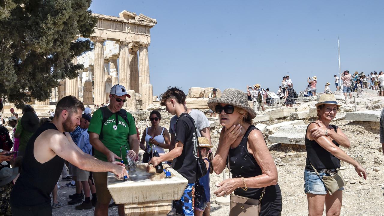 Tourists at the Acropolis during a heatwave on July 20, 2023 in Athens. More Aussies are travelling to Europe in the shoulder seasons to avoid the extreme heat. Picture: Milos Bicanski/Getty Images