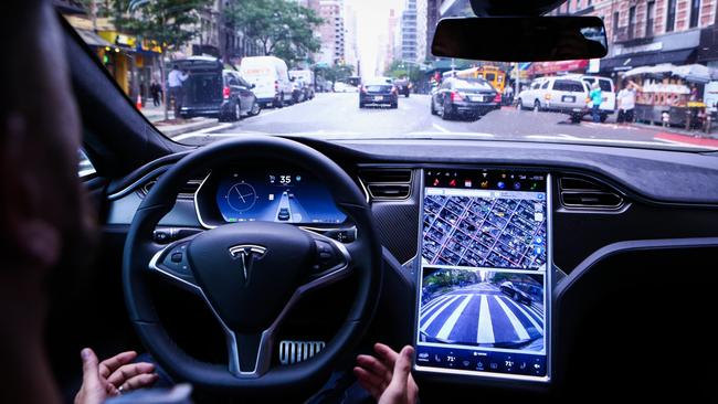 Look, no hands: A driver behind the wheel of a Tesla Model S equipped with Autopilot hardware and software. Picture: Bloomberg News