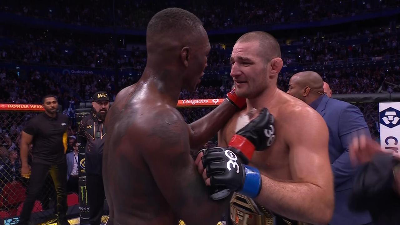 Israel Adesanya and Sean Strickland embrace.