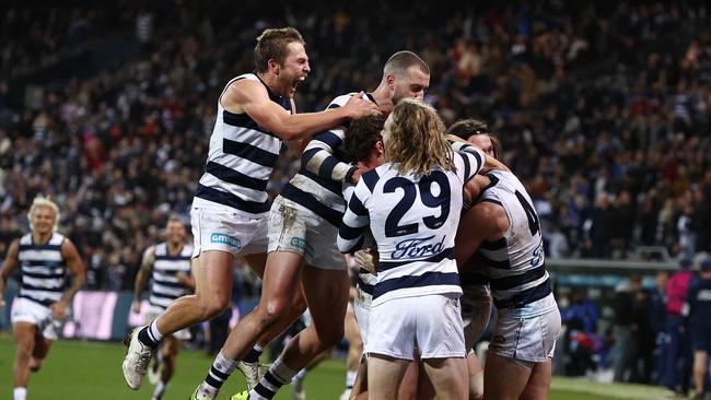 Cats players mob Gary Rohan of the Cats after his after-the-siren goal in 2021.