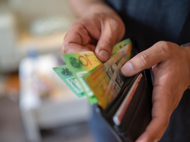 a male taking money out of a wallet, Australian cash generic spending