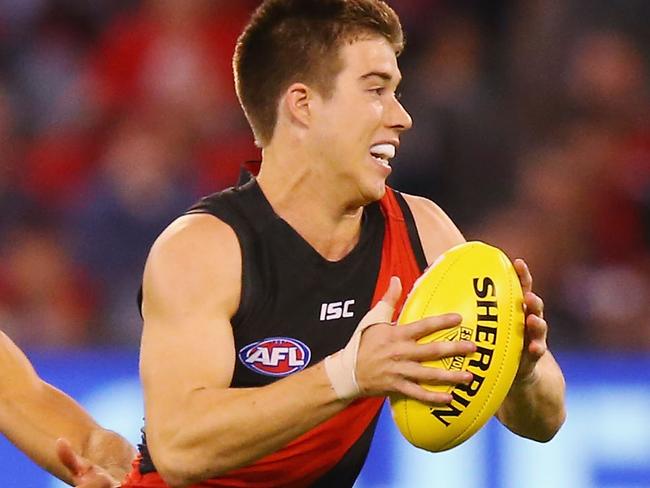 MELBOURNE, AUSTRALIA - MARCH 25:  Zach Merrett of the Bombers runs with the ball away from Paul Puopolo of the Hawks during the round one AFL match between the Essendon Bombers and the Hawthorn Hawks at Melbourne Cricket Ground on March 25, 2017 in Melbourne, Australia.  (Photo by Michael Dodge/Getty Images)