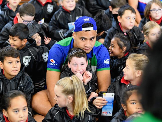 Eliesa Katoa hugs a student during a school visit while he was with the New Zealand Warriors. Picture: Getty Images