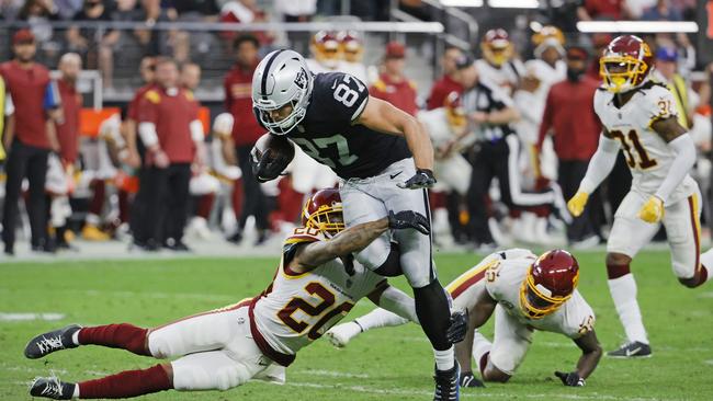 Foster Moreau runs through a tackle from Deshazor Everett. Photo by Ethan Miller/Getty Images