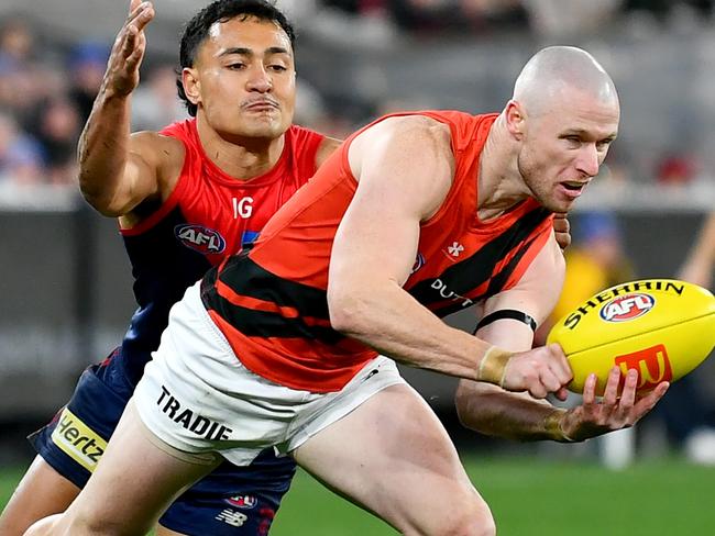 MELBOURNE, AUSTRALIA - JULY 13: Nick Hind of the Bombers handballs whilst being tackled by Andy Moniz-Wakefield of the Demons during the round 18 AFL match between Melbourne Demons and Essendon Bombers at Melbourne Cricket Ground, on July 13, 2024, in Melbourne, Australia. (Photo by Josh Chadwick/AFL Photos/via Getty Images)