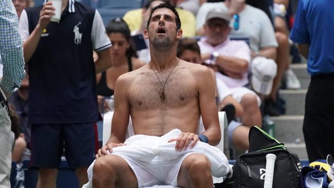 Novak Djokovic of Serbia takes a break from the heat while playing against Marton Fucsovics of Hungary. Picture: AFP