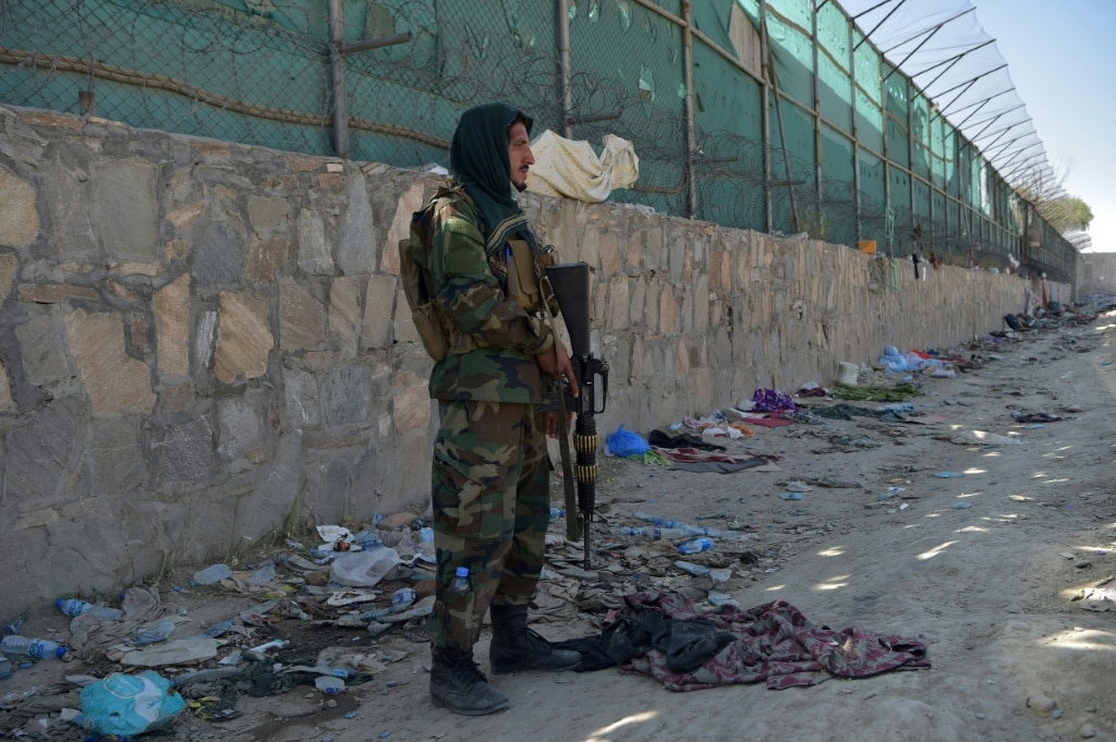 A Taliban fighter is pictured at the site of the Kabul airport bombing, which killed scores of people including 13 US troops