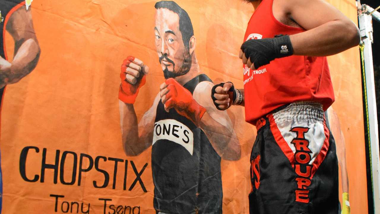 DOUBLE TAKE: 'Chopsticks' next to his immortalised painting at Fred Brophy's boxing tent. Picture: Matt Collins