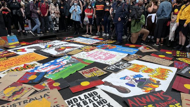 Demonstrators from the Warriors of Aboriginal resistance group have laid signs on the ground. Picture: Brianna Travers