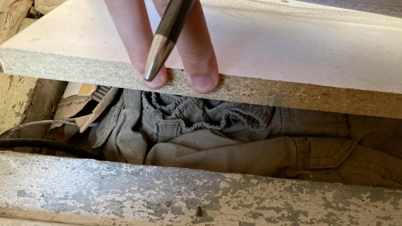 Clothes stuffed into wall and floor crevices at a Brisbane house that the tenant allegedly found a bag of meth and a crack pipe behind the bathroom sink and a secret stash hidden behind a wall clock. Source: shitrentals.org