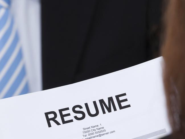 CAREERS: Cropped image of female candidate holding resume at desk during interview. Source: iStock