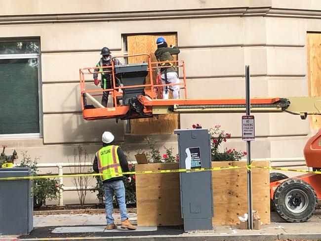 Workers board up windows in Washington DC. Picture: Chris Kenny