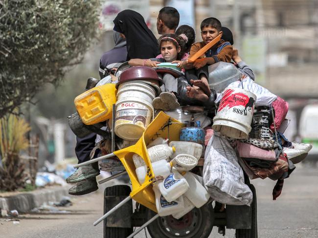 Children ride on a tricycle loaded with belongings and other items as they flee bound for Khan Yunis. Picture: AFP