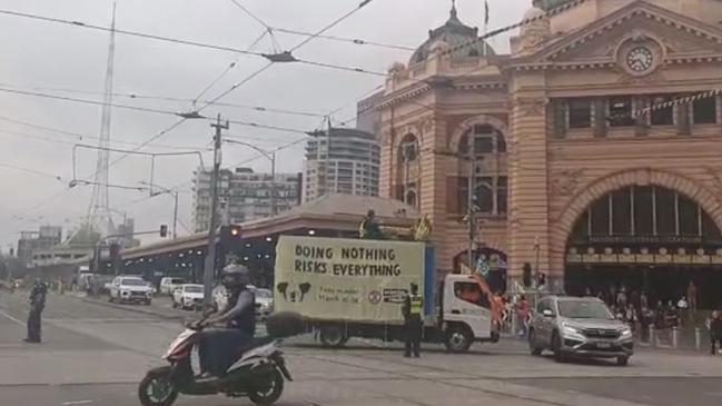 Police speak to protesters on the corner of Flinders and Swanston streets in Melbourne's CBD on March 19. Picture: Facebook