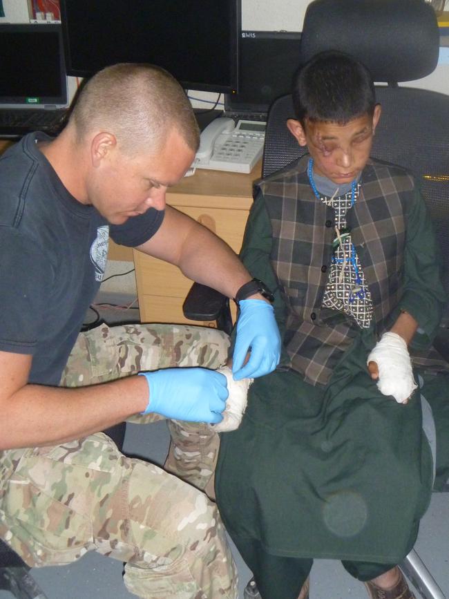 Major Dan Pronk bandages the boy’s hands. Picture: Supplied