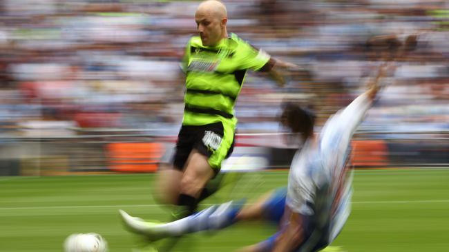 Aaron Mooy of Huddersfield Town is tackled by Joey van den Berg of Reading