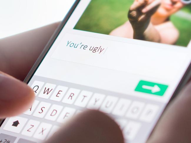 Internet troll sending mean comment to picture on an imaginary social media website with smartphone. Cyber bullying and bad behavior online concept.