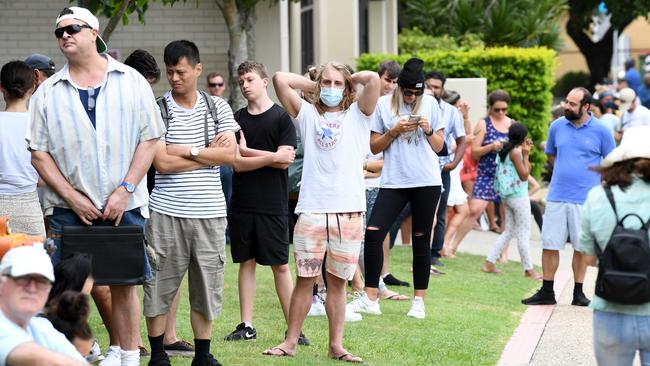 People are seen in long queues outside the Centrelink office in Southport on the Gold Coast after restaurants were shut down. (AAP Image/Dan Peled)