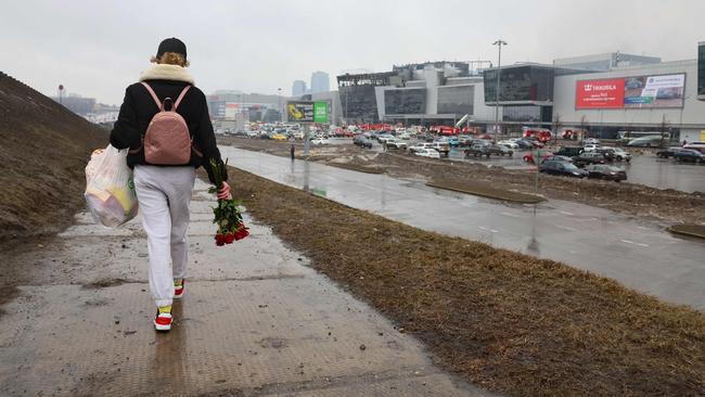 A woman walks to lay flowers at the scene of the gun attack at the Crocus City Hall concert hall in Krasnogorsk, outside Moscow. Picture: AFP