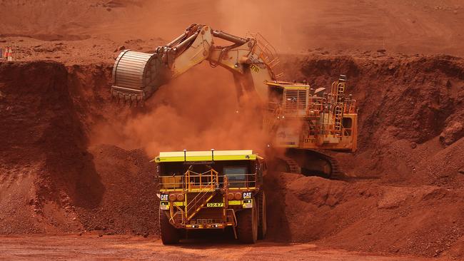 An excavator loads ore into an autonomous dump truck at Fortescue Metals Group Ltd.'s Solomon Hub mining operations in the Pilbara region, Australia, on Thursday, Oct. 27, 2016. Shares in Fortescue, the world's No. 4 iron ore exporter, have almost trebled in 2016 as iron ore recovered, and the company cut costs and repaid debt. Photographer: Brendon Thorne/Bloomberg via Getty Images