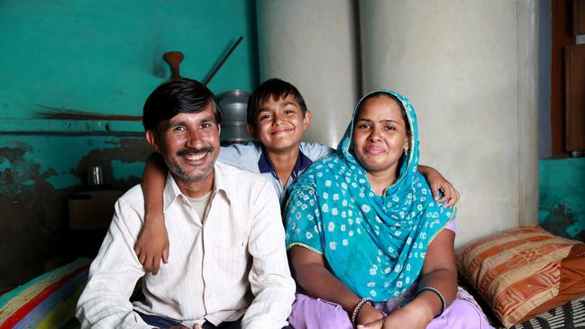 Cheerful Indian Family sitting on the cot smiling portrait with studio lights.