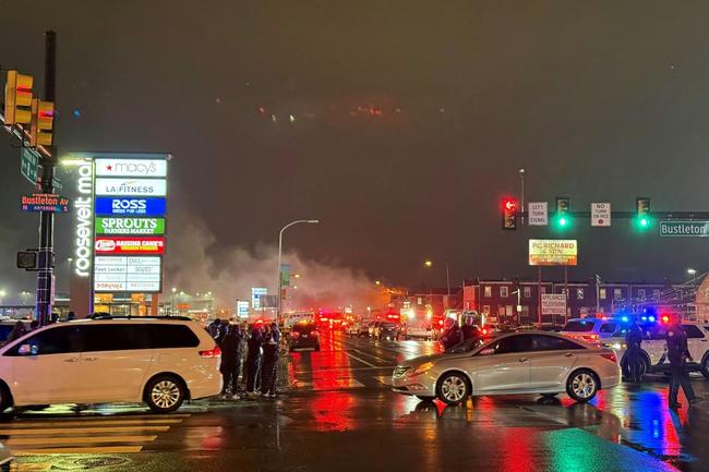 A plume of smoke and emergency responders can be seen after a small aircraft crashed in a neighborhood in Philadephia, Pennsylvania on January 31, 2025