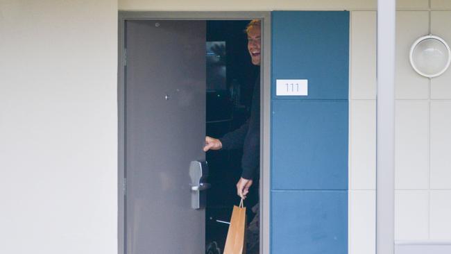 Billy Frampton grabs his lunch bag left outside his door at the Novotel on Friday. Picture: Brenton Edwards