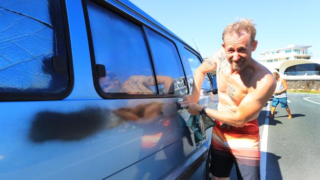 Christian Nicoll finishes cleaning off black spray paint from a Queensland registered van that was vandlised 50 metres from the Queensland-NSW border in Tweed Heads. Photo: Scott Powick
