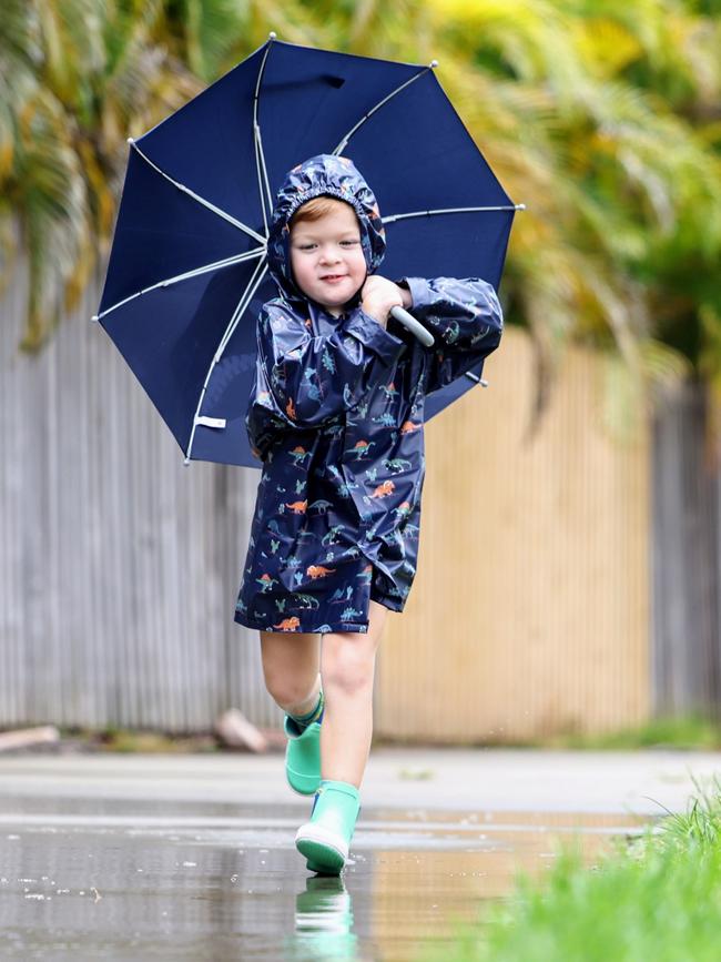 The start of summer has seen rainy weather return to Far North Queensland. Cairns youngster Noah Millard, 4, enjoys the return of the wet weather, dressing up in his raincoat and gumboots, and jumping into rain puddles outside his Smithfield home. Picture: Brendan Radke