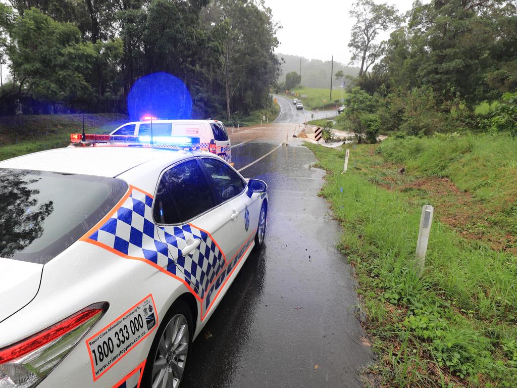 Queensland Police block access to a bridge on Tamborine Oxenford Road at Wongawallen after torrential rain caused the creek to break its banks. NCA NewsWire / Scott Powick