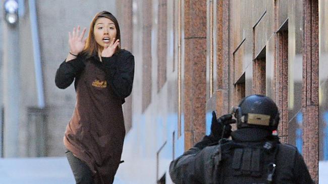 Elly Chen runs from the Lindt Cafe with her hands raised. Picture: AAP Image/Joel Carrett