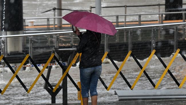 A Parramatta local takes a snap of the raging floodwaters after the Parramatta River broke its banks yesterday. Picture: Bianca De Marchi