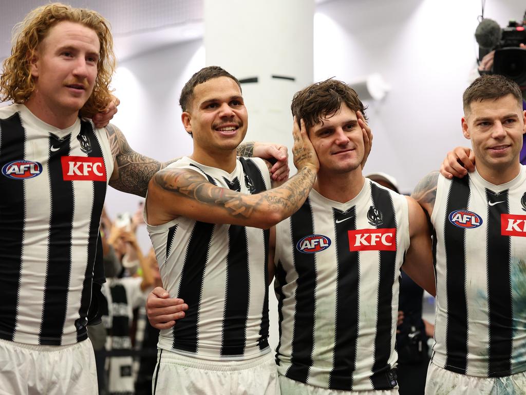 Bobby Hill of the Magpies covers the ears of Lachie Schultz as the club song is sung. Picture: Paul Kane