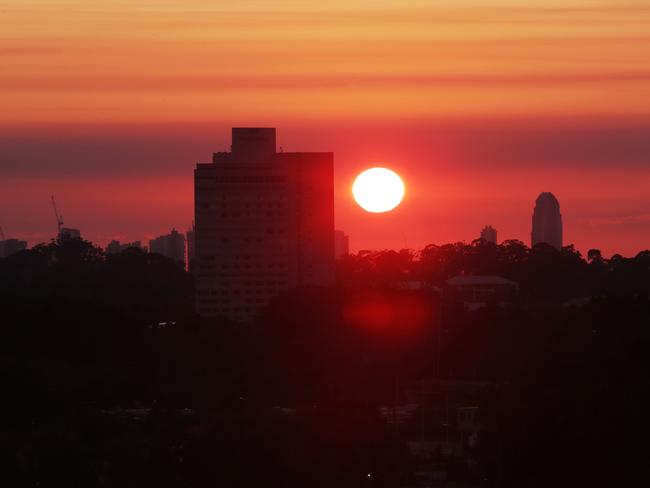 Maroon sky in the morning ,Blues warning.  A smoky haze over the Gold Coast made for a spectacular sunrise this morning with Royal pines in the foreground. Picture Glenn Hampson
