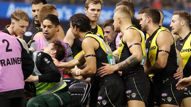 Tigers players console teammate Reece Conca as he is stretchered from the field.