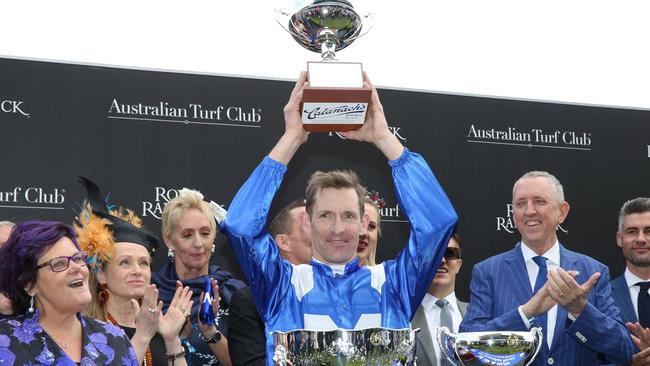 Another day, another Winx win: jockey Hugh Bowman holds up the Winx Stakes trophy for the first time, flanked by connections. Picture: AFP