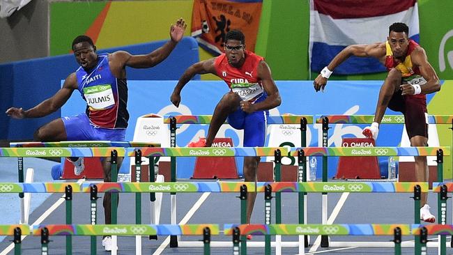 Going: Haiti's Jeffrey Julmis crashes in to a hurdle early on ...