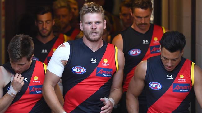 Michael Hurley leads the Bombers out against the Demons at Metricon Stadium in 2020.