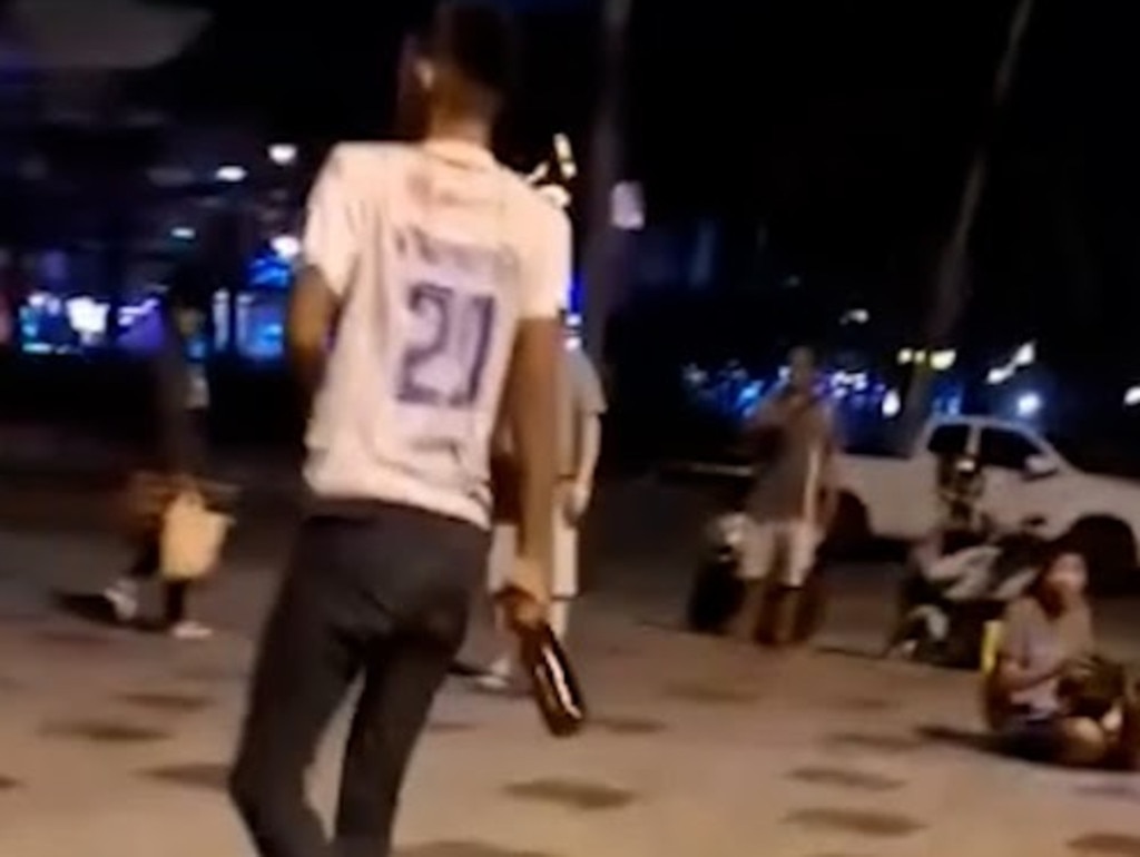 One person can be seen grabbing a glass bottle before smashing it over the foreigner's head. Picture: Asia Pacific Press