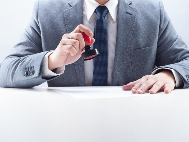 Businessman stamping the document at the desk.